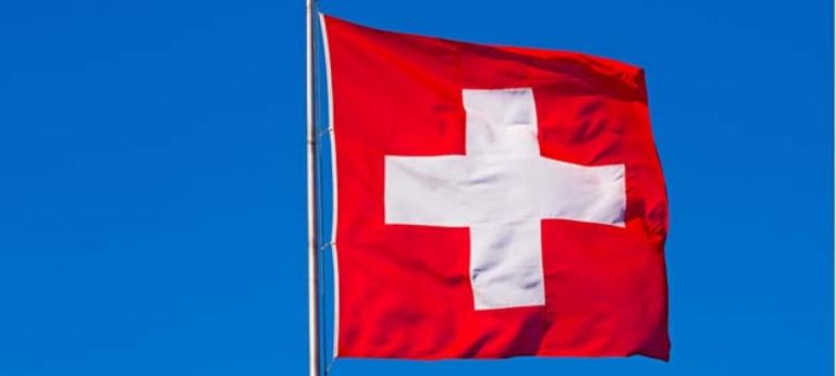 Flagge der Schweiz vor blauem Himmel