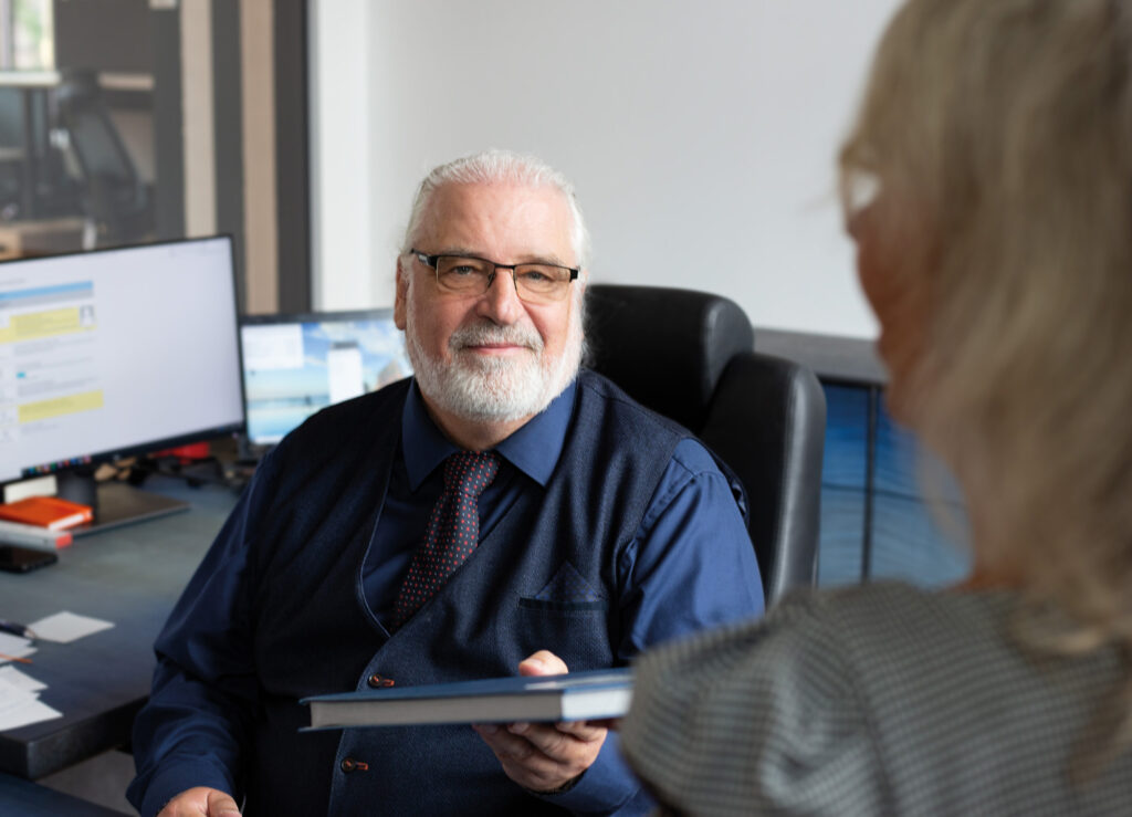 SONAPRO Geschäftsführer Jens Knöfler lächelt auf seinem Bürostuhl