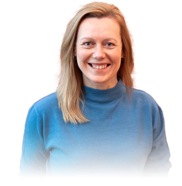 Bild einer Frau im blauem Rollkragenpullover, sichtbar bis zur Schulter und lachend in die Kamera schauend (Jacqueline Überheide)