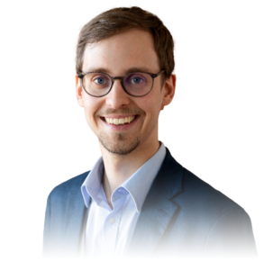 Bild eines Mannes im blauem Anzug, sichtbar bis zur Schulter und lachend in die Kamera schauend (Marius Knöfler)